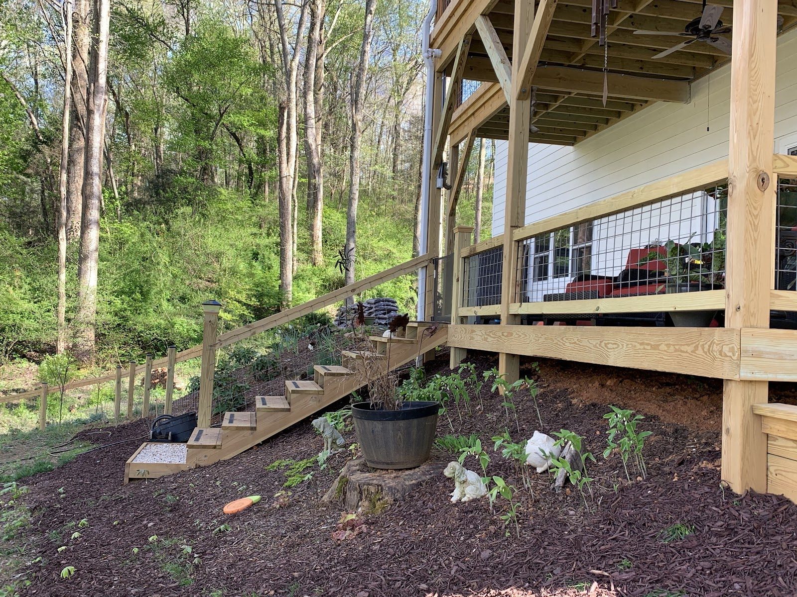 Wood rail fence following the hillside beside a home and steps